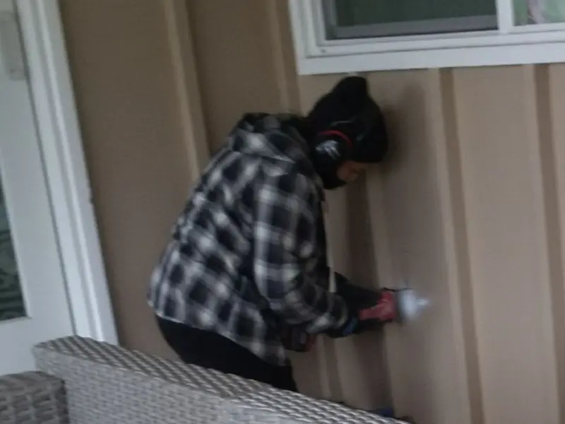 Professional electrician installing an exterior outlet in Holiday